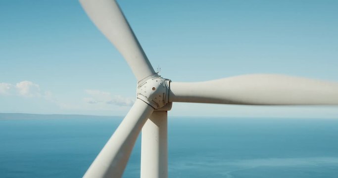Cinematic aerial view of large wind turbine producing clean sustainable energy, green energy revolution