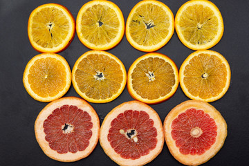 assorted of slice citrus and grapefruit fruits on black background.