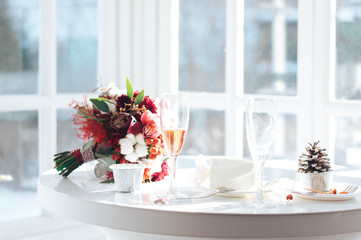 wedding bouquet and champagne glasses on a white table