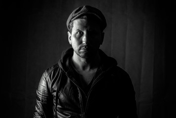 Obraz premium Portrait of a handsome bearded young man with a hat. Photos in the studio on a black background.