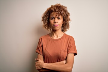 Beautiful african american woman with curly hair wearing casual t-shirt over white background...