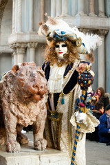 Fototapeta na wymiar CARNIVAL OF VENICE: Magistrate posing next to the winged lion in Venice.