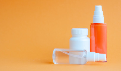 Close-up of two portable plastic bottles with disinfectant antiseptic gel and one bottle of pills...