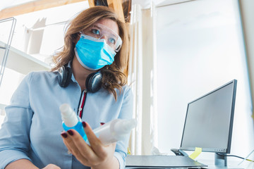 Frau mit Atemschutz maske arbeitet im Büro oder in Home office. Corona virus konzept.