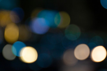 Bokeh einer Stra&szlig;e bei Nacht mit verschiedenen Lichtern in mehreren Farben im Hintergrund