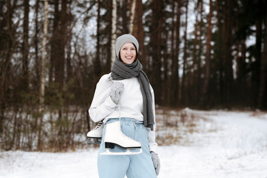 Portrait of happy woman with ice skates in winter