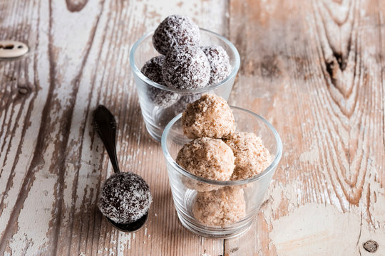 Glasses of vegan protein balls with millet, coconut, cocoa and nuts