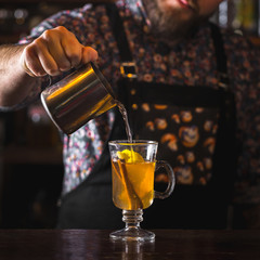 bartender preparing classic hot toddy cocktail