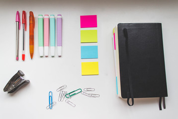 Oficina con rotulador, bolígrafo, notas, clips, libreta en un escritorio