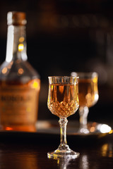 Bourbon in glasses on the bar with a bottle in the background