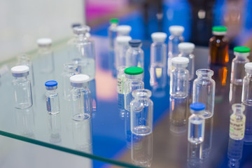 Pharma industry, science, medicine, experiment and healthcare concept. Medical empty glass bottles in showcase at pharmaceutical exhibition, pharmacy laboratory