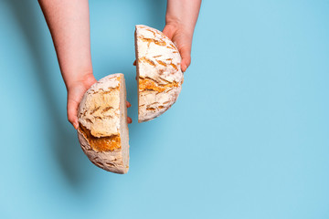 Bread sliced in two held in womans hands. Sourdough bread