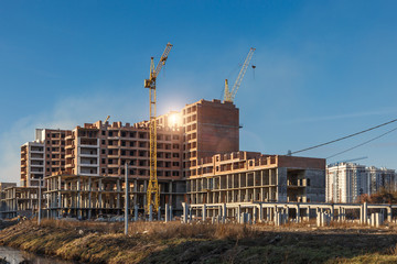 Construction site background. Hoisting cranes and new multi-storey buildings. I.ndustrial...