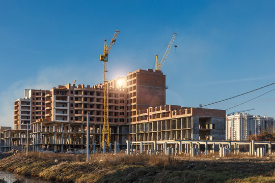 Construction site background. Hoisting cranes and new multi-storey buildings. I.ndustrial background.Building construction site work against blue sky.monolithic technology.