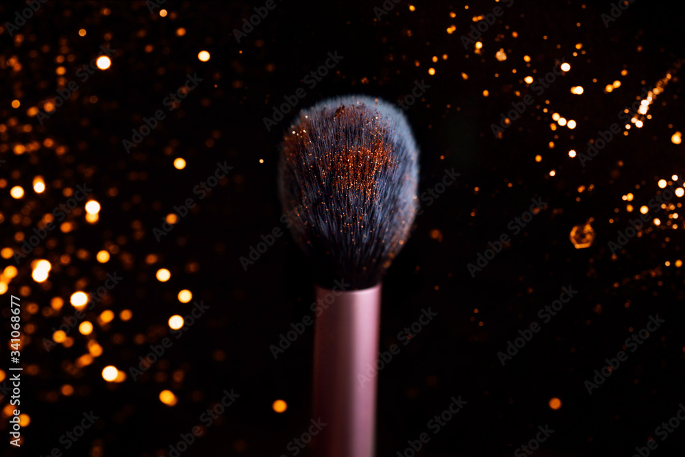 Wall mural pink make up brush stanting up on dark isolated background studio shot