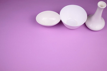 White dishes on a pink background.