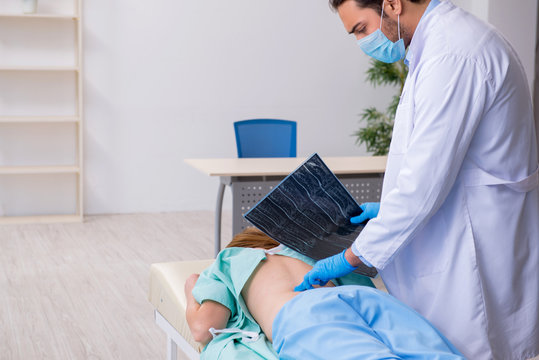 Young back injured woman visiting male doctor chiropractor
