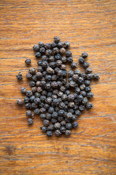 Black Pepper Corns Over A Wood Surface