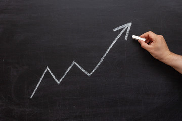 White up arrow on a chalkboard. The concept of success