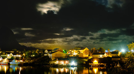 Fototapeta premium view of the Reine village at night, Lofoten islands, Rorbu in the light of lanterns
