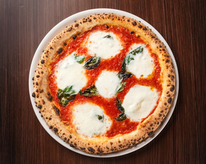 Pizza Margherita with bufala on wooden table. Original Italian recipe. Pizza Margarita with Tomatoes, Basil and Mozzarella Cheese. Top view