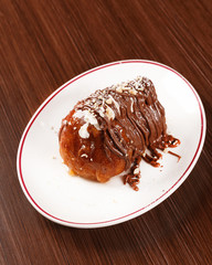 Traditional Italian desert with rum and Nutella cream. Wooden table.