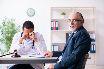 Male doctor in courthouse meeting with lawyer