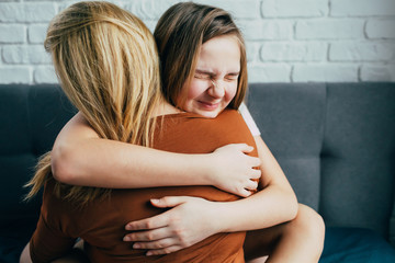 Mother day. Beautiful young woman and her charming little daughter are hugging and smiling. mom gently hugged her daughter, the girl snuggles up to her cheek with squinting facial expression. - 341072288
