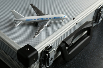 toy airplane and suitcase close up. trip concept