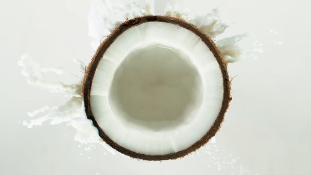 Super Slow Motion Shot of Milk Splashing on Coconut at 4K.