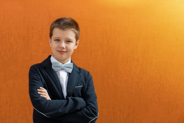 Portrait of a confident boy, 10 years old, in a suit and bow tie.