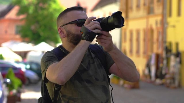 Man walking in the old town and doing photos on the camera 
