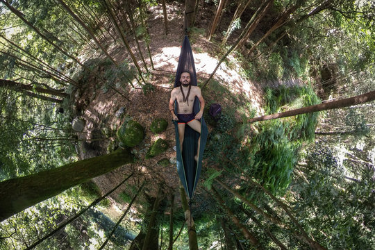 Chico con rastas relaj&aacute;ndose en una hamaca en el bosque