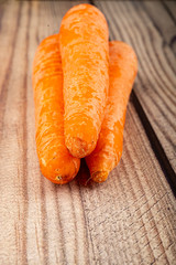 Juicy orange carrots on a wooden background. Close up.