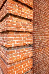 Three- dimensional elements of brickwork on the wall. Terraces on an old brick wall. Old weathered...