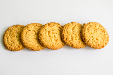 Five crispy with zest cookies on a white background