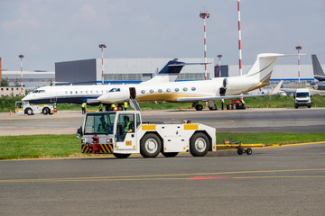 Obraz na płótnie Canvas 4123. Airport towing tug in front of plane parking with business jets.