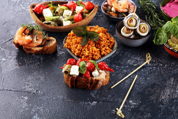 Antipasti Appetizer sweet cherry peppers stuffed with soft cheese feta, olives with oil. Seafood and anchovies with olives and dried tomatoes in oil