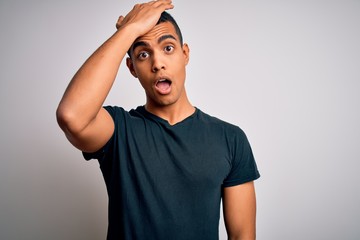 Young handsome african american man wearing casual t-shirt standing over white background surprised...