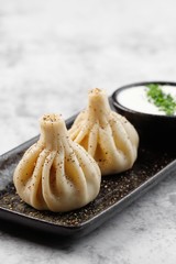 Georgian authentic cuisine. KHINKALI with sour cream. Best for promotion. Marble table.  Close-up and top view. Flat lay