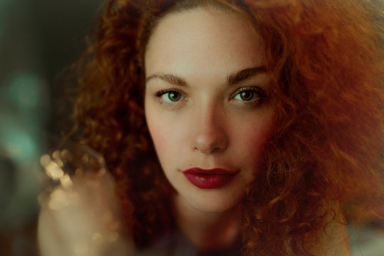 Portrait of red-haired woman looking at camera