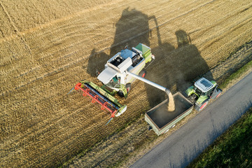 Germany, Bavaria, Drone view of combine harvester unloading grain on tractor