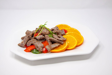 A plate of stir-fry beef with oranges, green pepper and red pepper