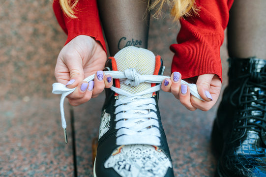 Close-up of young woman putting on roller skates