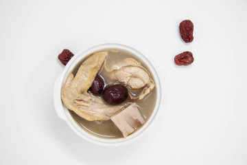 Top view of a plate of chicken soup with red dates