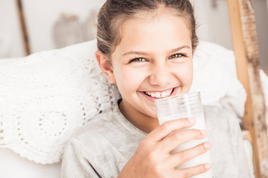 Portrait of happy girl drinking glass of milk - Powered by Adobe
