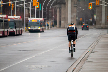 Cyclist biking through The Exhibition Centre in Toronto. Empty streets. Covid-19.