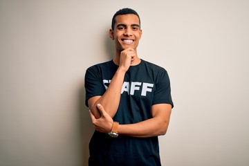 Young handsome african american worker man wearing staff uniform over white background looking...