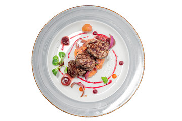 veal medallions with vegetables on a white background