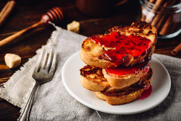 Stack of french toasts with berry marmalade on white plate